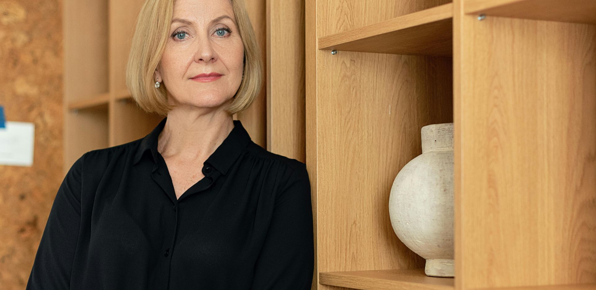 Confident businesswoman standing in an office setting, showcasing leadership.